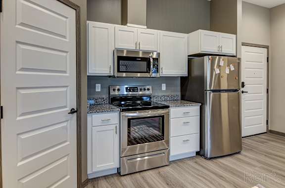 A kitchen with white cabinets and stainless steel appliances.