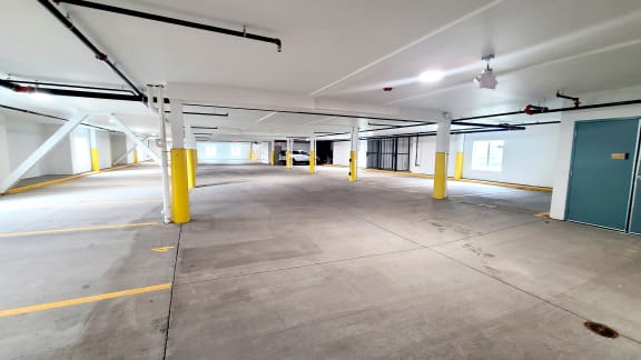 a parking garage with yellow pillars and a green door