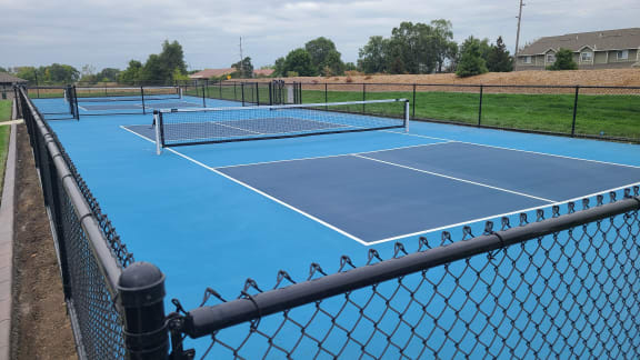 a blue tennis court with a net and a fence