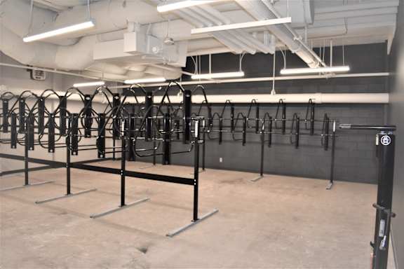 A gym with a row of black weight racks.