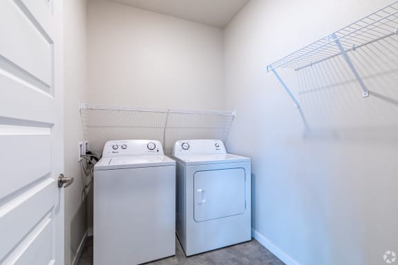 an empty laundry room with two washes and a dryer in it