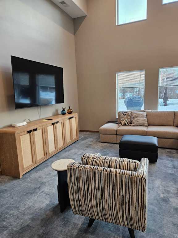 A living room with a striped chair and a couch.