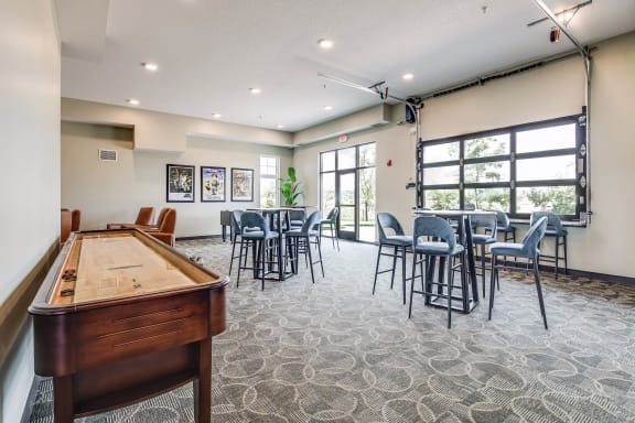 a community room with a pool table and tables