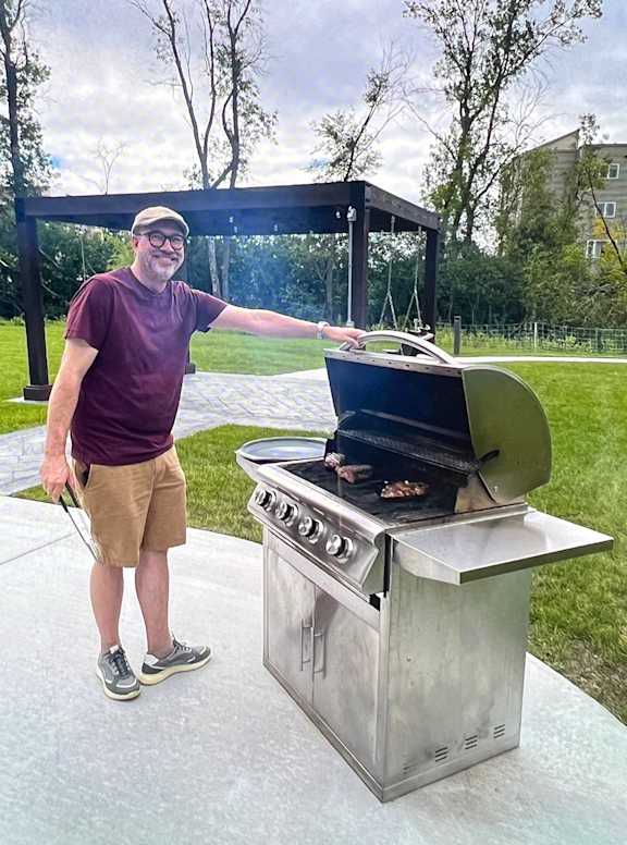 A man is grilling food on a portable stove.