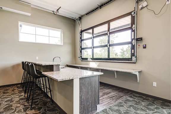 A kitchen area with a counter and chairs.
