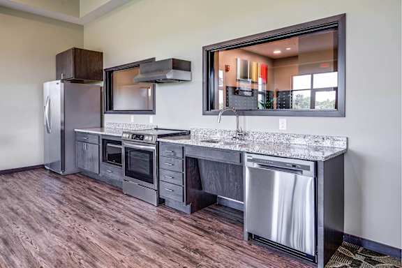 A modern kitchen with a wooden floor and stainless steel appliances.