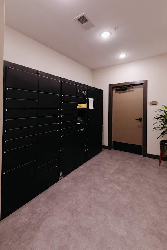 a row of black lockers in a room with an open door