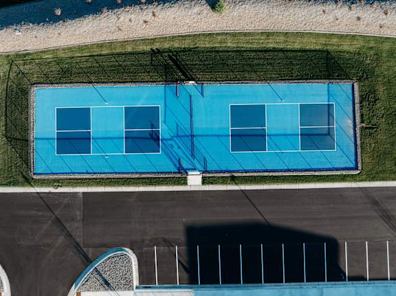 an aerial view of an empty tennis court with a blue court