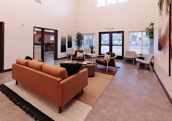 a living room with couches and chairs and a rug
