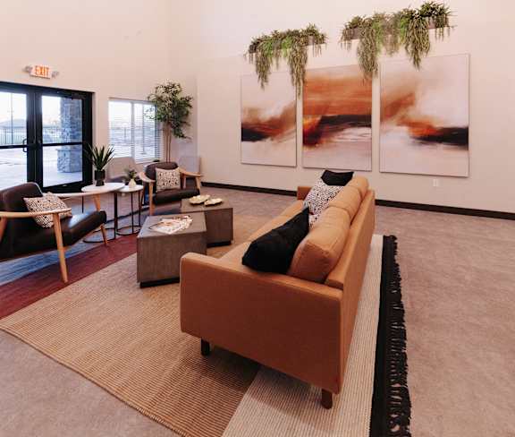 a living room with couches and chairs and art on the wall