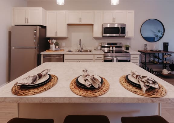 a kitchen with a marble counter top with three plates on it