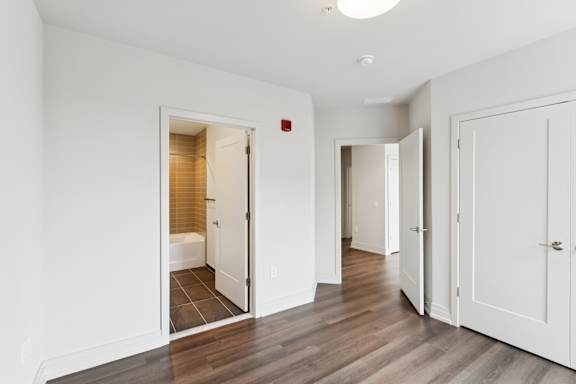 A white room with a wooden floor and a white door.