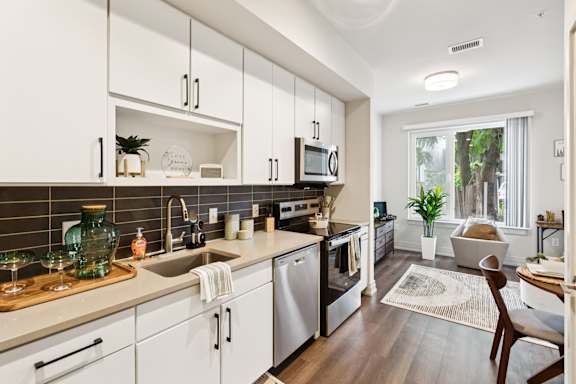 A modern kitchen with white cabinets and a wooden countertop.