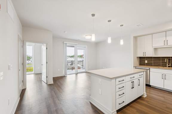 A kitchen with white cabinets and a large island.