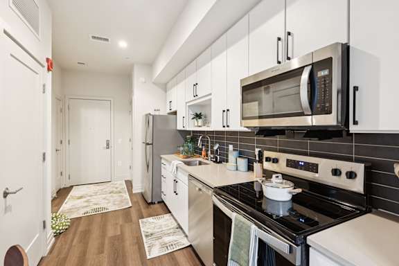 A modern kitchen with a stove, microwave, and oven.