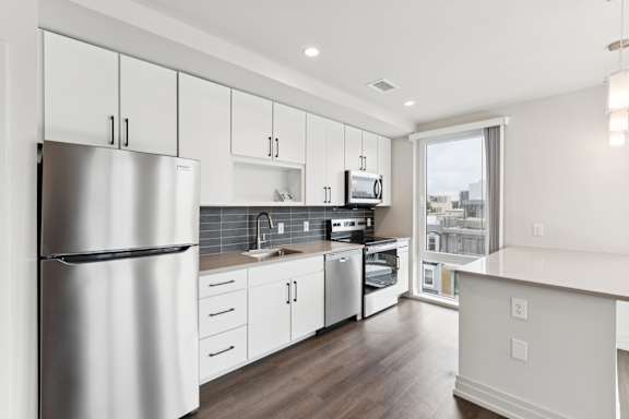 A modern kitchen with stainless steel appliances and white cabinets.