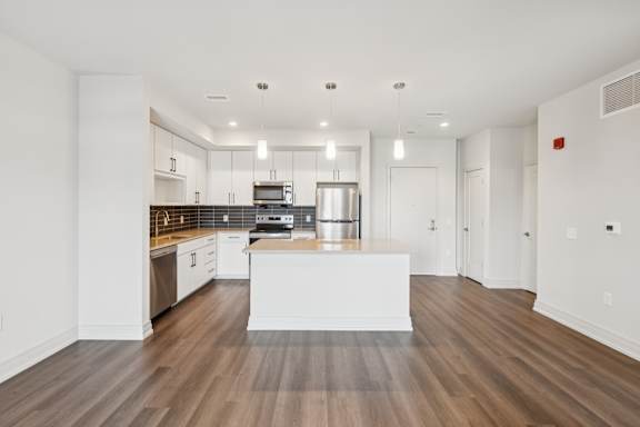 A modern kitchen with a white island in the middle.