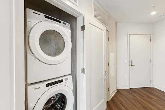 A white Whirlpool washing machine is in a white door.