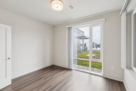A room with a sliding glass door leading to a balcony.