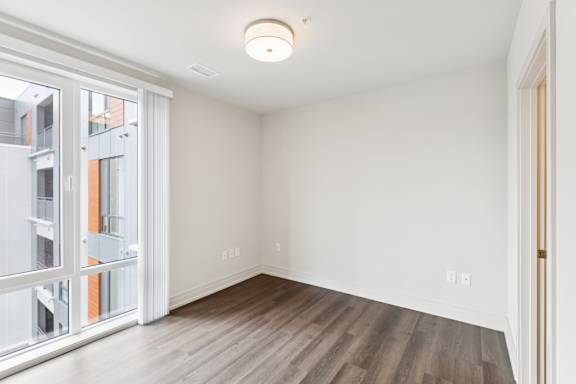 A room with a sliding glass door leading to a balcony.