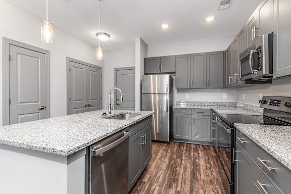 a kitchen with gray cabinets and white countertops