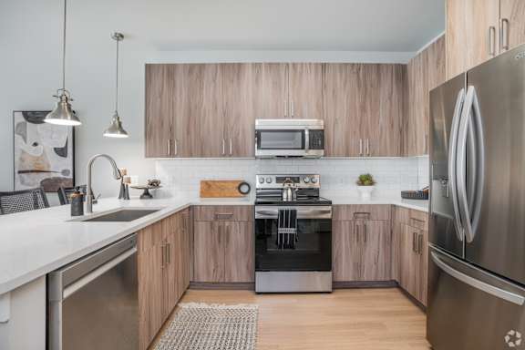 A modern kitchen with wooden cabinets and stainless steel appliances.