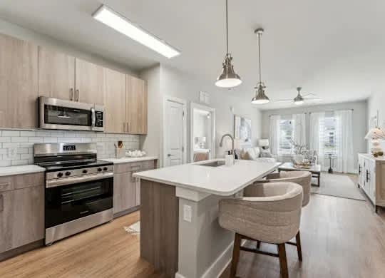 A modern kitchen with a large island and wooden floors.