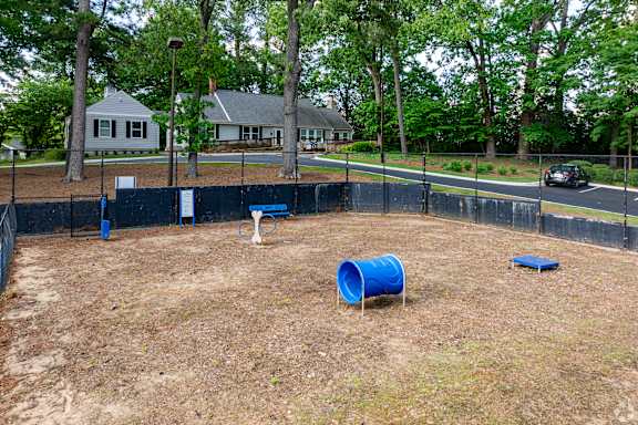 A blue barrel sits in the middle of a dirt field.