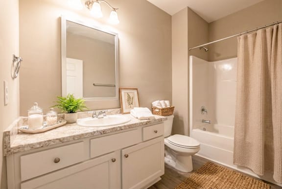 Bathroom with tub and curtain at Club Villas Apartments, Kathleen, GA
