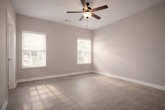 Room with a ceiling fan and two windows at Club Villas Apartments, Georgia