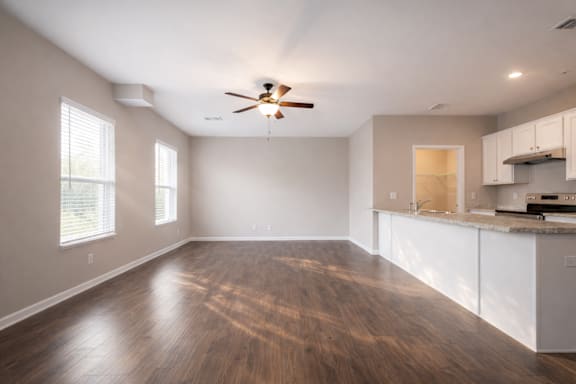 Spacious room with a ceiling fan and wooden flooring at Club Villas Apartments, Kathleen, GA, 31047