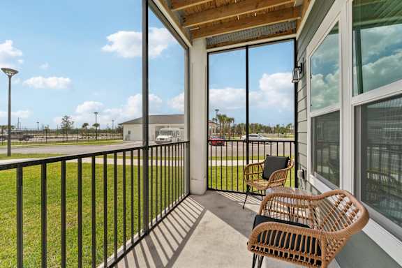 A balcony with a chair and a table at The Hendry Apartments, Fort Myers, FL, 33905