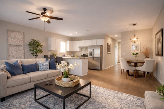Modern living room with a beige couch, a coffee table, and a ceiling fan at Club Villas Apartments, Georgia, 31047