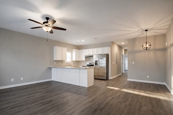 Spacious room with ceiling fan and kitchen area at Club Villas Apartments, Kathleen, GA, 31047