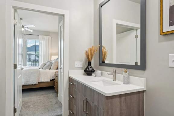 A bathroom with a white sink and a mirror above it.