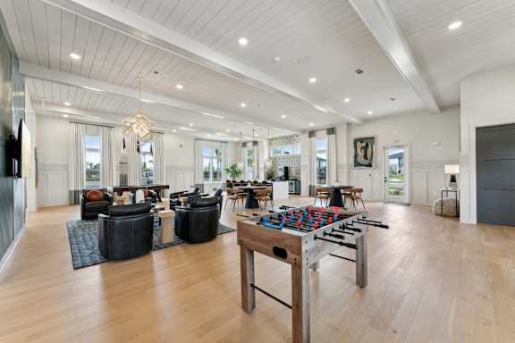 A spacious living room with a large wooden table and comfortable seating at The Hendry Apartments, Fort Myers, Florida