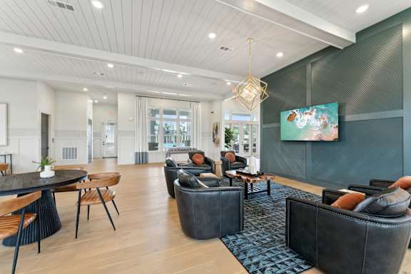 A modern living room with a black couch and a painting on the wall at The Hendry Apartments, Florida, 33905