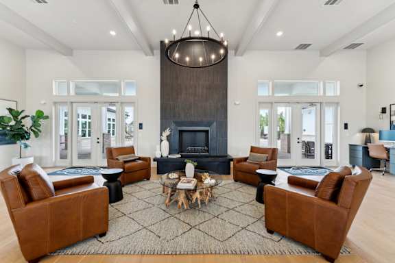 A living room with a fireplace and a chandelier at The Hendry Apartments, Fort Myers, 33905