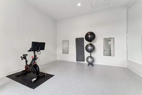 A room with a stationary bike, a black ball, and a black exercise ball at The Hendry Apartments, Florida, 33905