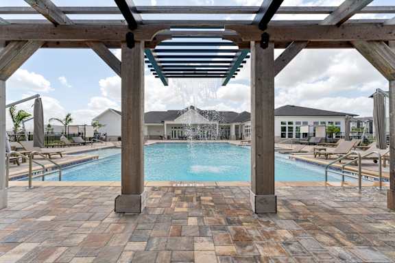 A pool area with a wooden pergola and tiled flooring at The Hendry Apartments, Fort Myers, 33905