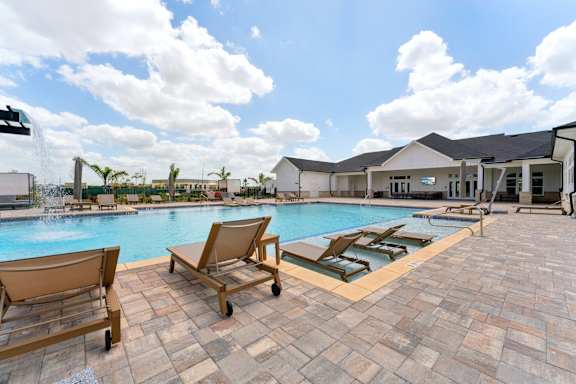 A pool with sun loungers and a building in the background at The Hendry Apartments, Fort Myers