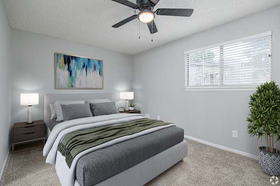 A bedroom with two beds, a ceiling fan, and a painting on the wall.