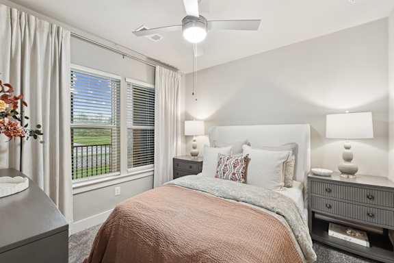 A bedroom with a bed, nightstand, and window with blinds.