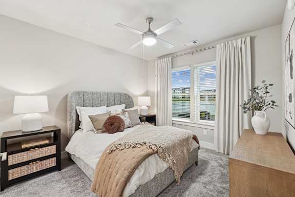 A bedroom with a large bed and a ceiling fan.
