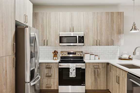 A modern kitchen with wooden cabinets and stainless steel appliances.