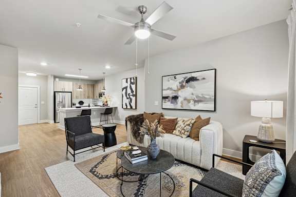 A living room with a white couch, a black chair, and a coffee table.