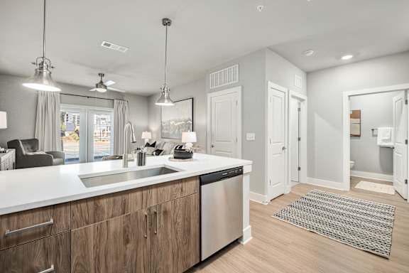 A modern kitchen with wooden cabinets and stainless steel appliances.at The Ashton at East Park Apartments, Kennesaw