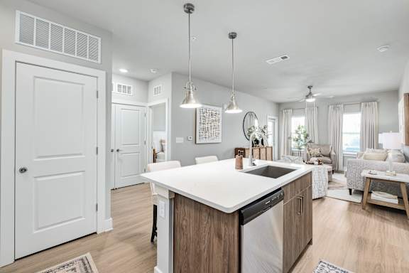 A modern kitchen with a large island and a dining area.at The Ashton at East Park Apartments, Georgia