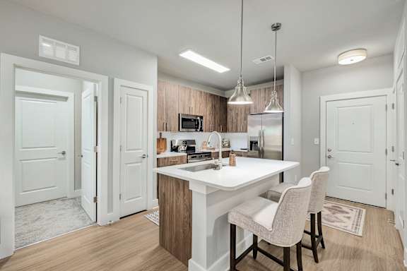 A kitchen with a white countertop and a white dining table with two chairs.at The Ashton at East Park Apartments, Kennesaw, GA, 30144