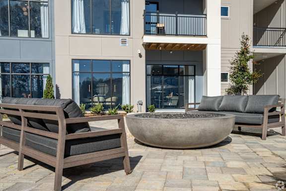 A patio with a couch, table and chairs.